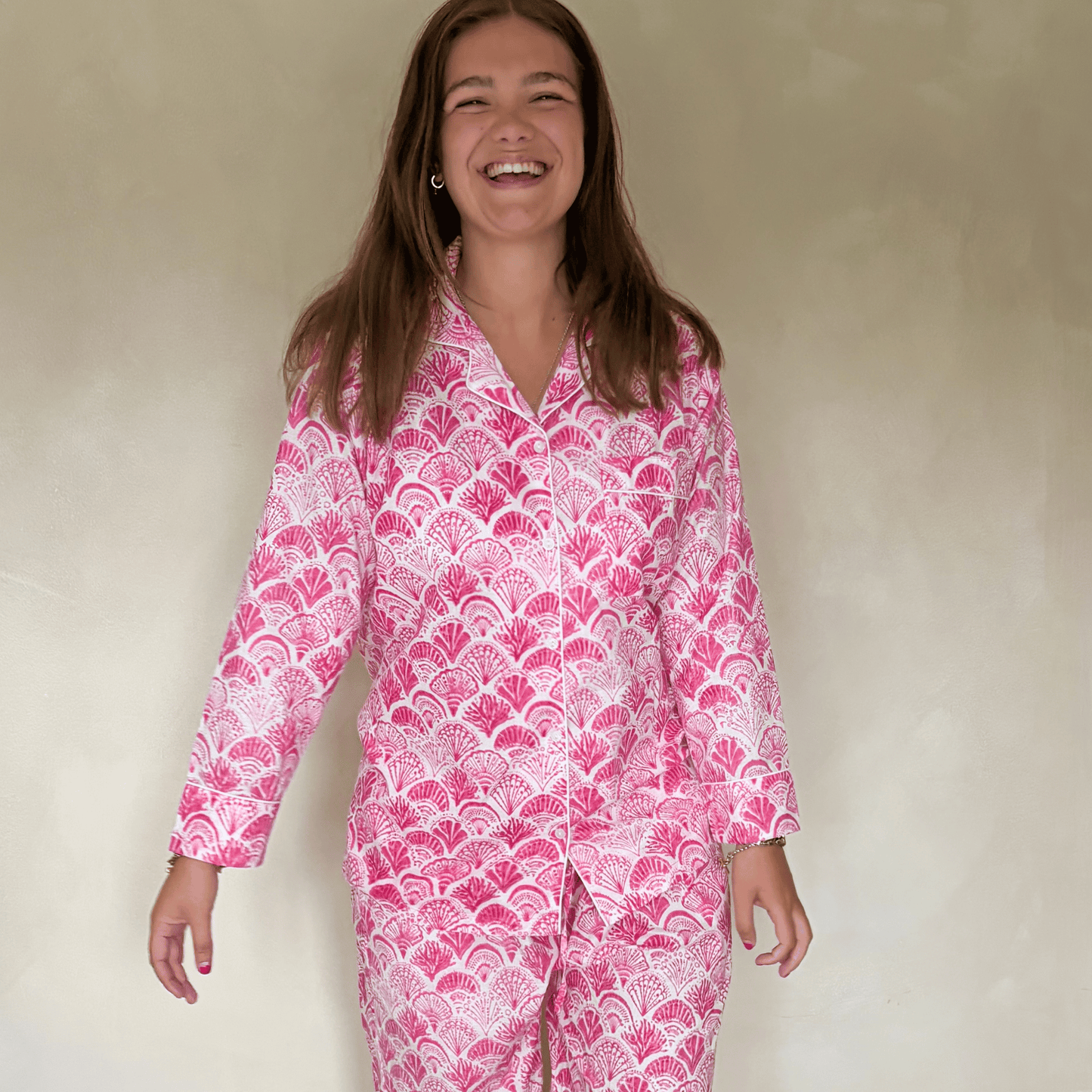 Bright pink shell print cotton pyjamas with long sleeves and elastic waist on white background